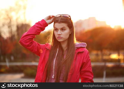 Portrait of a beautiful young traveler woman with a backpack, bright orange sunset light, traveling along Europe, freedom and active lifestyle concept