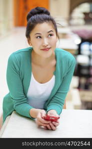 Portrait of a beautiful young woman calling by phone in shop