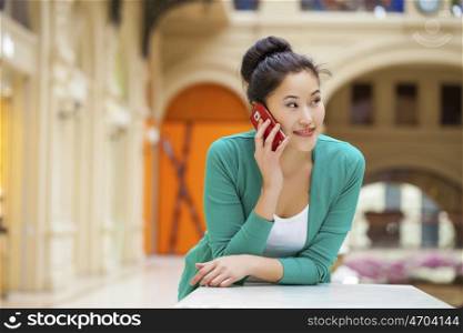 Portrait of a beautiful young woman calling by phone in shop