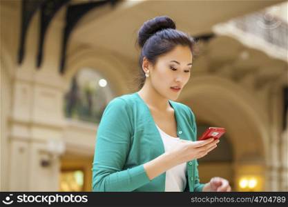 Portrait of a beautiful young woman calling by phone in shop