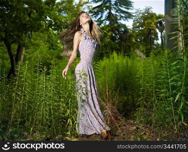 Portrait of a beautiful young woman dancing in the forest