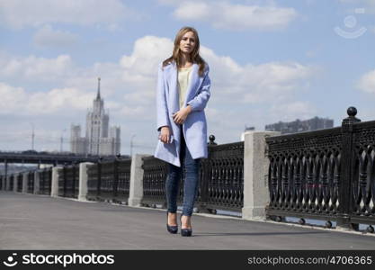 Portrait of a beautiful young woman in a blue coat