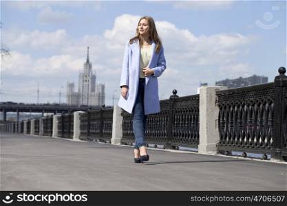 Portrait of a beautiful young woman in a blue coat