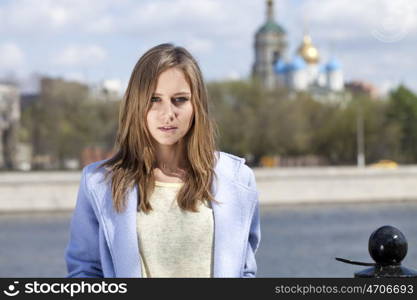 Portrait of a beautiful young woman in a blue coat