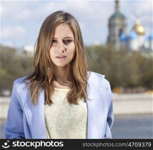 Portrait of a beautiful young woman in a blue coat