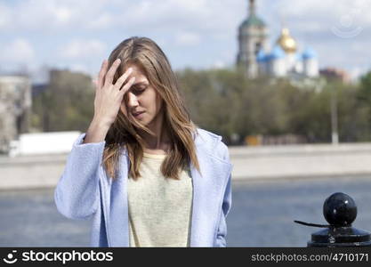 Portrait of a beautiful young woman in a blue coat