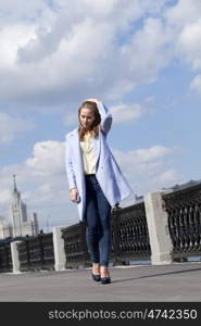 Portrait of a beautiful young woman in a blue coat