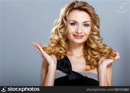 Portrait of a beautiful young woman in black dress with curly hair