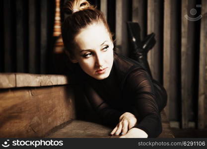 Portrait of a beautiful young woman lying on the wooden steps