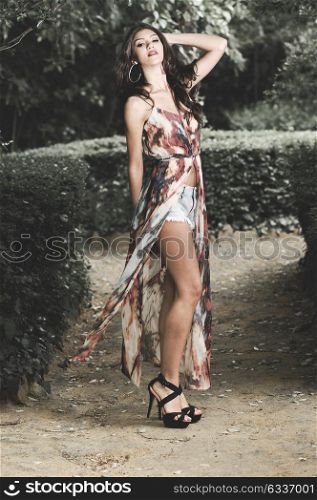Portrait of a beautiful young woman, model of fashion, in a garden