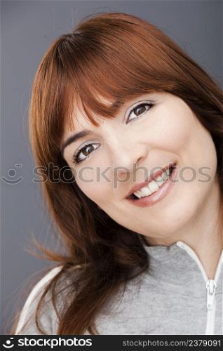 Portrait of a beautiful young woman over a gray background