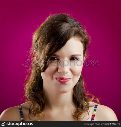 Portrait of a beautiful young woman over a pink background 