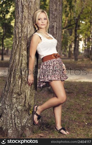 Portrait of a beautiful young woman posing near a tree