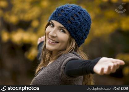 Portrait of a beautiful young woman relaxing with arms open and enjoying the fall season