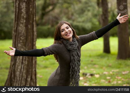 Portrait of a beautiful young woman relaxing with arms open and enjoying the nature