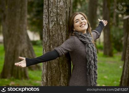 Portrait of a beautiful young woman relaxing with arms open and enjoying the nature