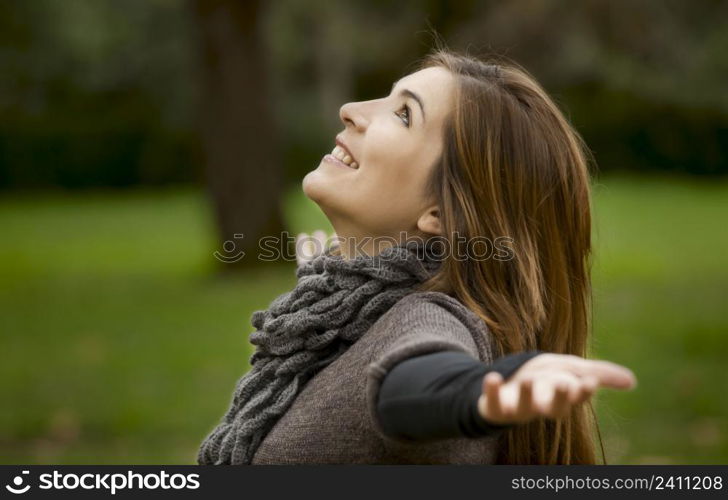 Portrait of a beautiful young woman relaxing with arms open and enjoying the nature