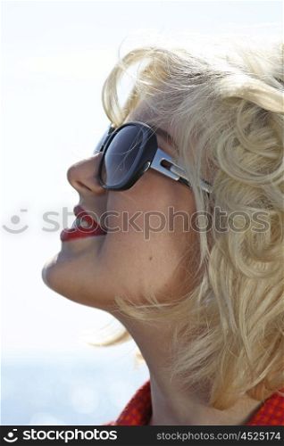 Portrait of a beautiful young woman retro styled wearing sunglasses