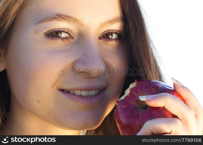 portrait of a beautiful young woman with apple outdoor