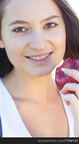 portrait of a beautiful young woman with apple outdoor