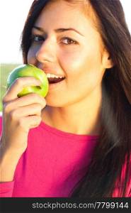 portrait of a beautiful young woman with apple outdoor