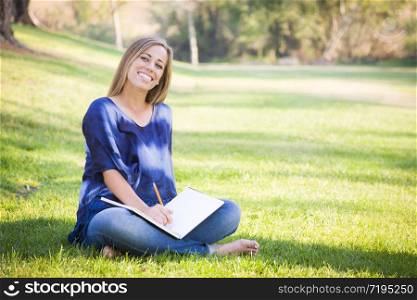 Portrait of a Beautiful Young Woman With Book Outdoors at the Park.