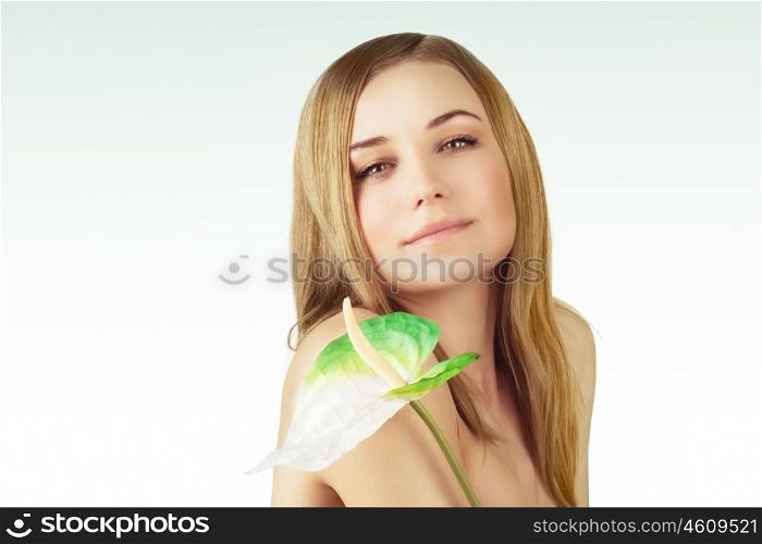 Portrait of a beautiful young woman with calla flower over clear background, healthy lifestyle, beauty treatment, enjoying dayspa