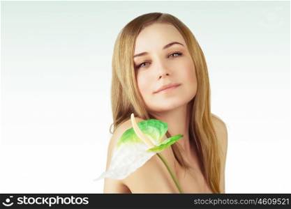 Portrait of a beautiful young woman with calla flower over clear background, healthy lifestyle, beauty treatment, enjoying dayspa