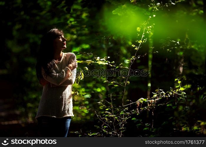 portrait of a beautiful young woman with closed eyes in the woods in the sun.. portrait of a beautiful young woman with closed eyes in the woods in the sun