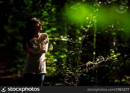 portrait of a beautiful young woman with closed eyes in the woods in the sun.. portrait of a beautiful young woman with closed eyes in the woods in the sun