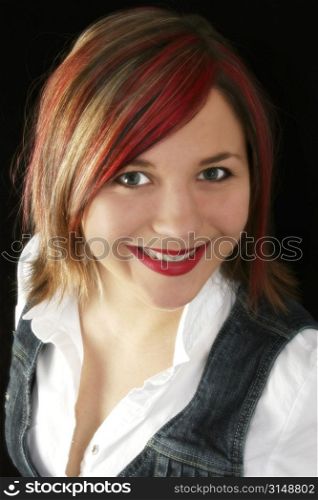 Portrait of a beautiful young woman with red, blonde and black highlights in her hair. Great smile.