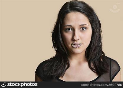 Portrait of a beautiful young woman with sprinkled lips over colored background