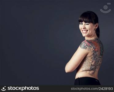 Portrait of a beautiful young woman with tattoos and winking