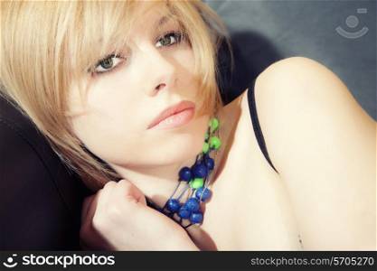 portrait of a beautiful younger blond woman in necklace