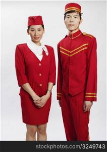 Portrait of a bellhop and an air stewardess standing together and posing