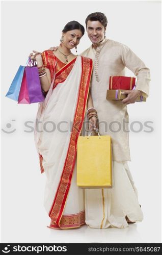 Portrait of a Bengali couple with shopping bags and gifts