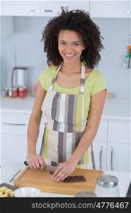 portrait of a black woman cookingchocolate cake