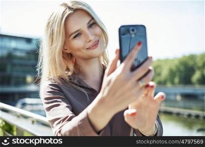 Portrait of a blond lady taking a selfie