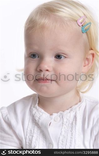 Portrait Of A Blond Toddler Girl With A Timid Expression