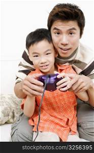 Portrait of a boy and his father playing a video game