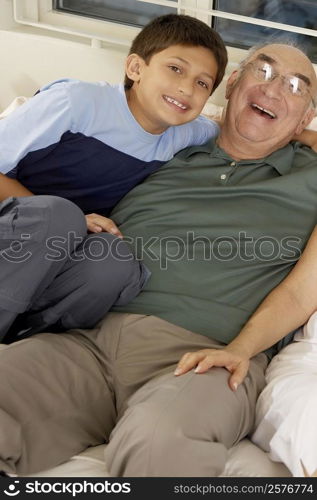 Portrait of a boy and his grandfather on a couch