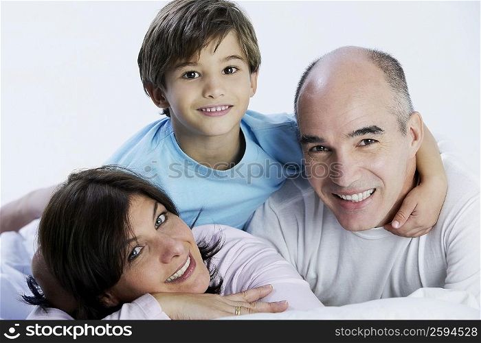 Portrait of a boy and his parents lying on the bed