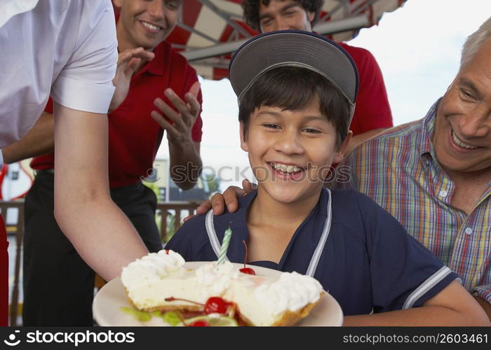 Portrait of a boy celebrating his birthday with his grandfather in a restaurant