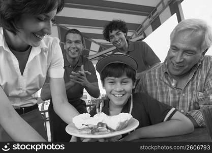 Portrait of a boy celebrating his birthday with his grandfather in a restaurant