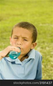 Portrait of a boy drinking beverage from a bottle