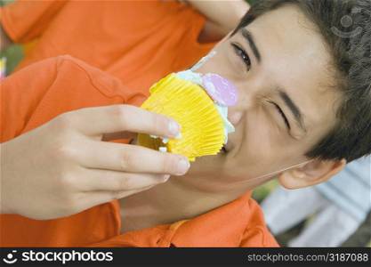 Portrait of a boy eating a cupcake