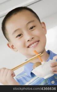 Portrait of a boy eating noodles with chopsticks