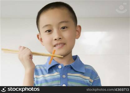 Portrait of a boy eating noodles with chopsticks