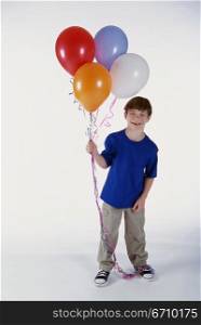 Portrait of a boy holding a bunch of balloons