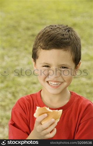 Portrait of a boy holding a burger